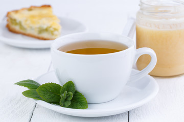 Mint tea with honey on wooden table.