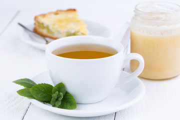 Mint tea with honey on wooden table.
