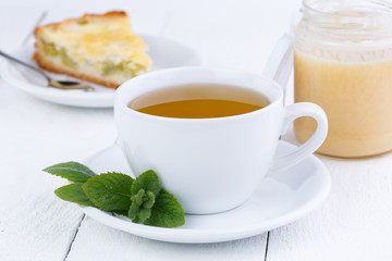 Mint tea with honey on wooden table.