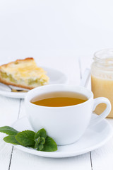 Mint tea with honey on wooden table.
