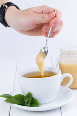 Mint tea with honey on wooden table.