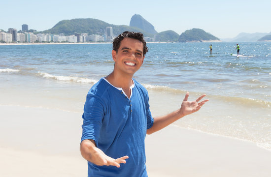 Fröhlicher junger Mann im blauen Shirt an der Copacabana