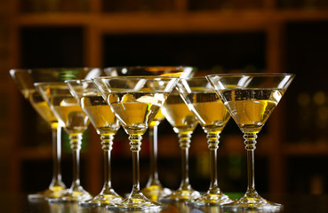 Glasses of cocktails on bar background