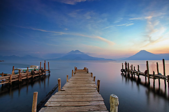 Fototapeta Colorful sunset at the Panajachel Pier with volcanoes in the background, Lake Atitlan, Guatemala, Central America