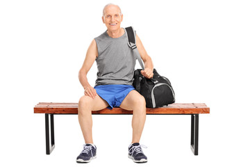 Fototapeta premium Active senior man sitting on a wooden bench