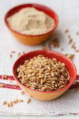 Spelt grains and flour in bowls