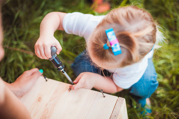 Little girl making Wooden birdhouse
