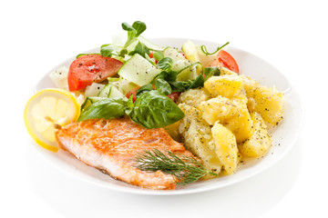 Fried salmon and vegetables on white background 