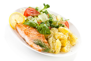 Fried salmon and vegetables on white background 