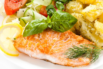 Fried salmon and vegetables on white background 