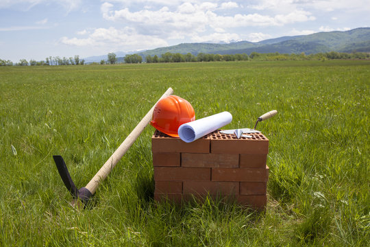 Construction tools and plan are prepared for starting of a new construction object on a green field.