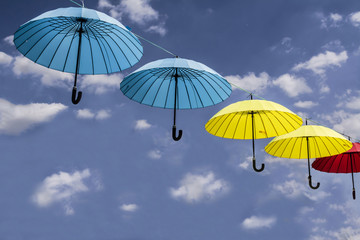 colored umbrellas hanging from a rope sky background