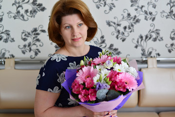 Woman with a bouquet of flowers in the room