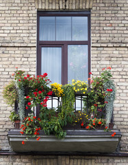 Fototapeta na wymiar Residential balcony decorated with flowers at summer 