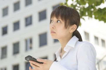 スマートフォンを見てがっかりする若い日本人女性