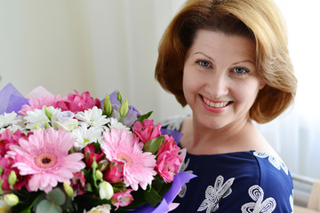 positive Woman with a bouquet of flowers in the room