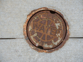 Rusty Iron cover provides access to a water main.