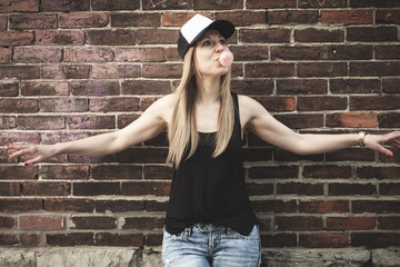 Beautiful modern girl near the brickwall.