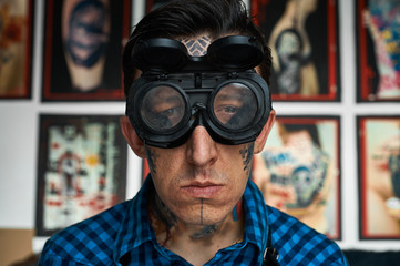 Portrait of tattoo artist in welder glasses