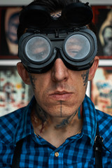 Portrait of tattooist in welder glasses