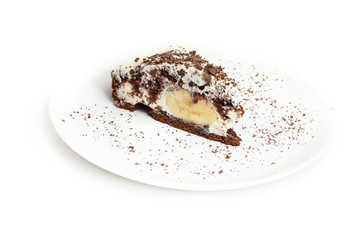 Piece of banana and chocolate cake on porcelain plate. Isolated on white