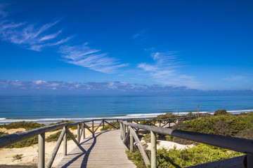 Holzsteg in Andalusien führt zum Strand am Meer