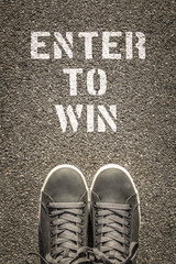 Enter to win stencil print on the asphalt road