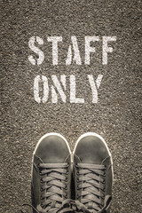 Staff only stencil print on the asphalt road