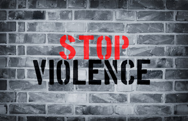 Stop Violence stencil print on the grunge white brick wall