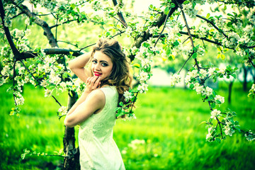 One pretty girl in the garden under the blossom tree