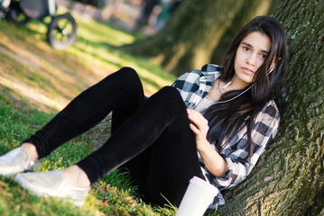 Young woman relaxing in Central Park with a coffee cup while lis © pio3