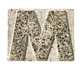 Letter M carved in a concrete block