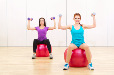 Fototapeta na wymiar Two sporty women at fitness club