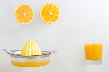 Halved orange with orange juice glass and squeezer with blank sp