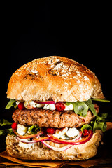 Close Up of Burger Piled High with Fresh Toppings