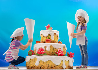 Children decorate a huge cake
