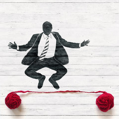 Businessman jumping over red thread