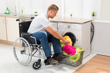 Disabled Man Putting Towels Into The Washing Machine