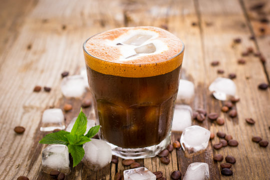 Ice coffee in a glass on the wooden table