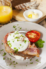 Poached egg and bacon on rye bread, healthy breakfast