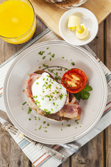 Poached egg and bacon on rye bread, healthy breakfast