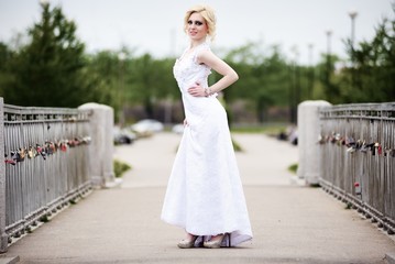 Fototapeta na wymiar Beautiful bride in white dress on bridge