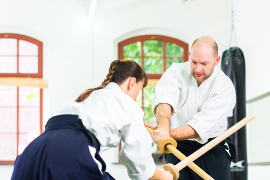 Man and woman having Aikido sword fight - Powered by Adobe