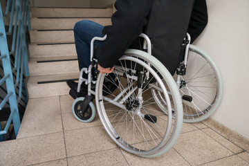 Fototapeta na wymiar Man On Wheelchair In Front Of Staircase