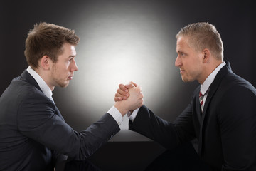 Two Young Businessman Arm Wrestling