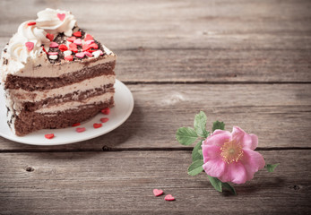 pink rose and cake on wooden background