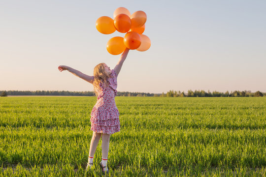 happy girl with orange balloons outdoor