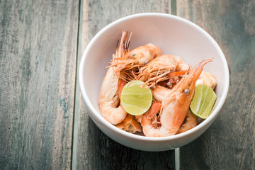 Shrimps and lemon in white bowl