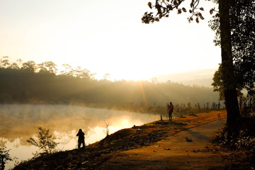 Photographer take a photo beside the lake at sunrise