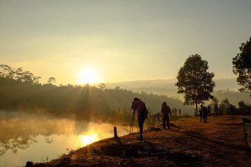 Photographer take a photo beside the lake at sunrise